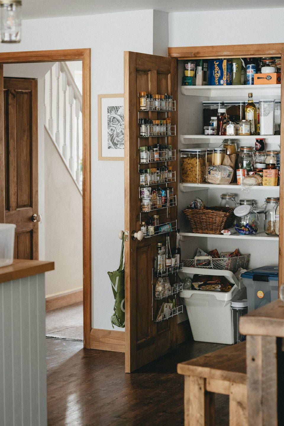 Neatly organized pantry with food items and spices on shelves.
